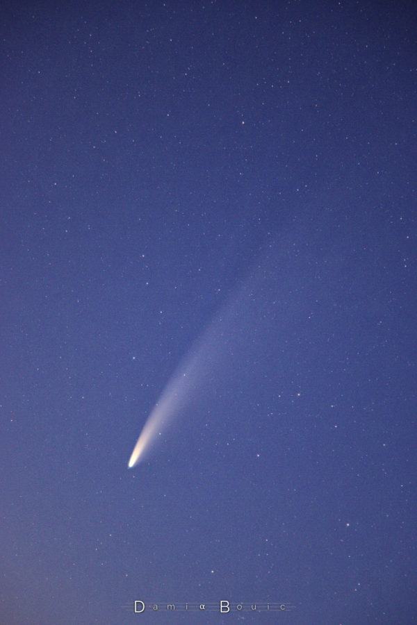 Comète, plan large, avec queue bien déployée sur fond stellaire bleuté