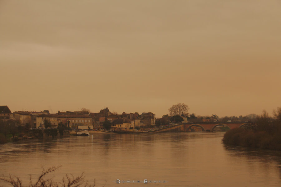 Zoom sur le Vieux Bergerac, avec le pont en pierre dont la partie centrale est masquée par l'île, le tout dans cette ambiance jaune