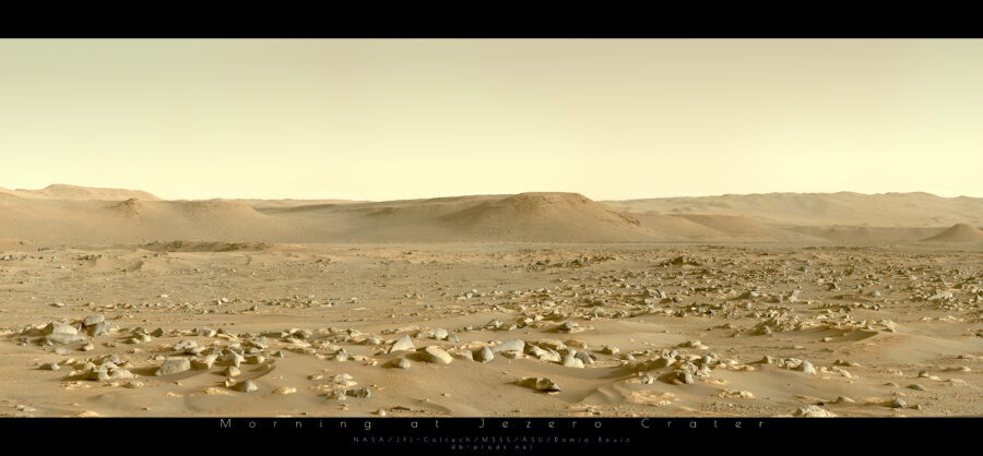 Paysage martien. C'est le matin, l'éclairage solaire rasant met en avant la richesse géologique du site, avec de nombreuses roches, la plupart assez arrondies et lisses, d'autres plus saillantes. Des petites dunes de sables semblent relier plusieurs îlots rocheux, notamment à gauche. Au fond, l'horizon est constitué de collines aux sommets plats, qui ondulent légèrement.