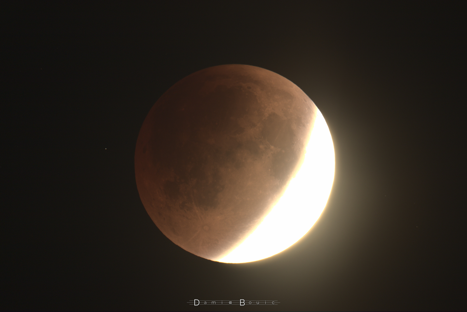 La partie encore dans la lumière solaire sur la Lune est surexposée sur ce clichée, pour mieux mettre en évidence la partie ombrée, qui présente des teintes rouges clairement visibles