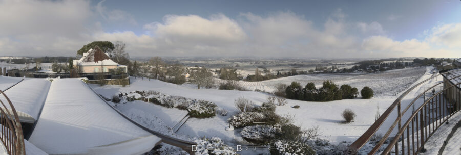 Image panoramique montrant la vallée de la dordogne couverte de neige, et dont les arbres émergent ci et là. Le temps est ensoleillé et quelques stratus errent dans le ciel.