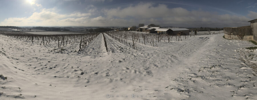 Panorama plus large de la vue précédente, qui dévoile une ferme à droite, dont les toits sont blancs.