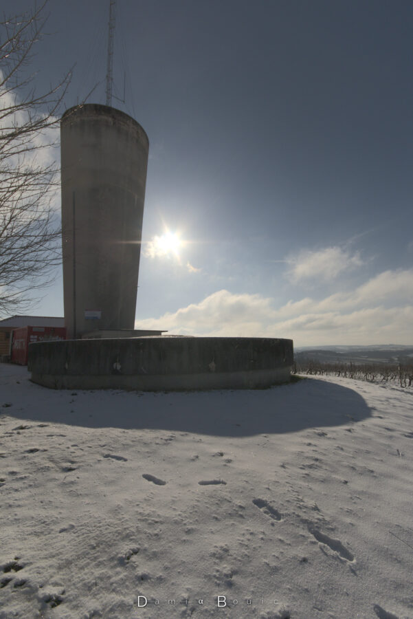 L'imposant chateau d'eau qui étire son ombre sur la surface immaculée de la neige au sol.