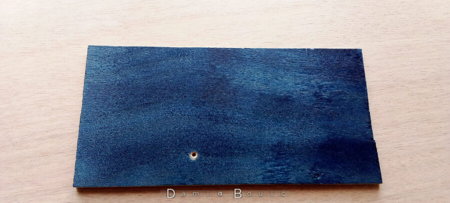 Test de peinture bleu métallisé sur une chute de contreplaqué.