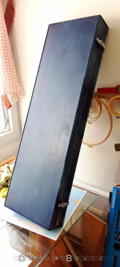 L'étui qui repose sur la table et le mur, un peu penché.