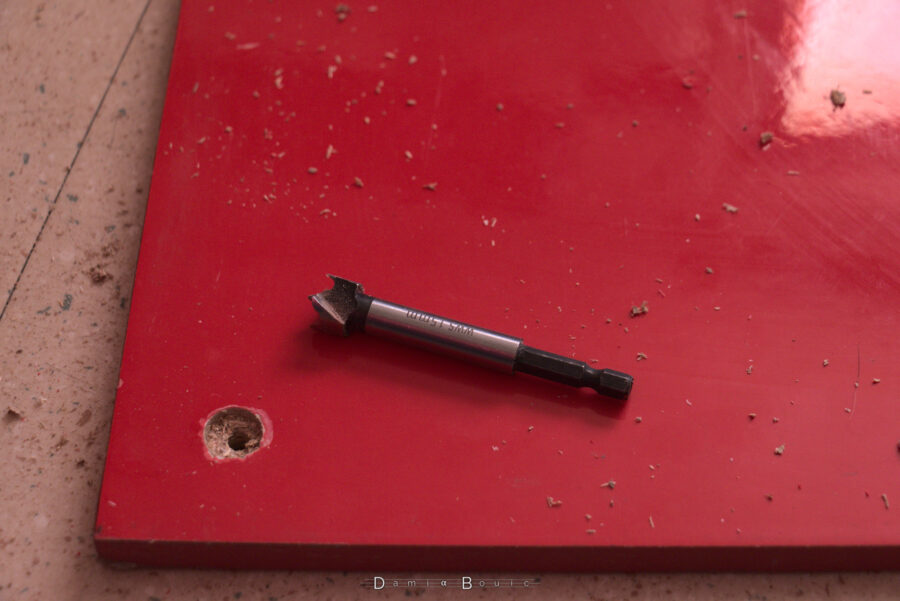 Un des trous de cette planche, avec un agrandissement de son entrée, réalisé par une mèche Forstner 15mm qu'on voit posée à côté