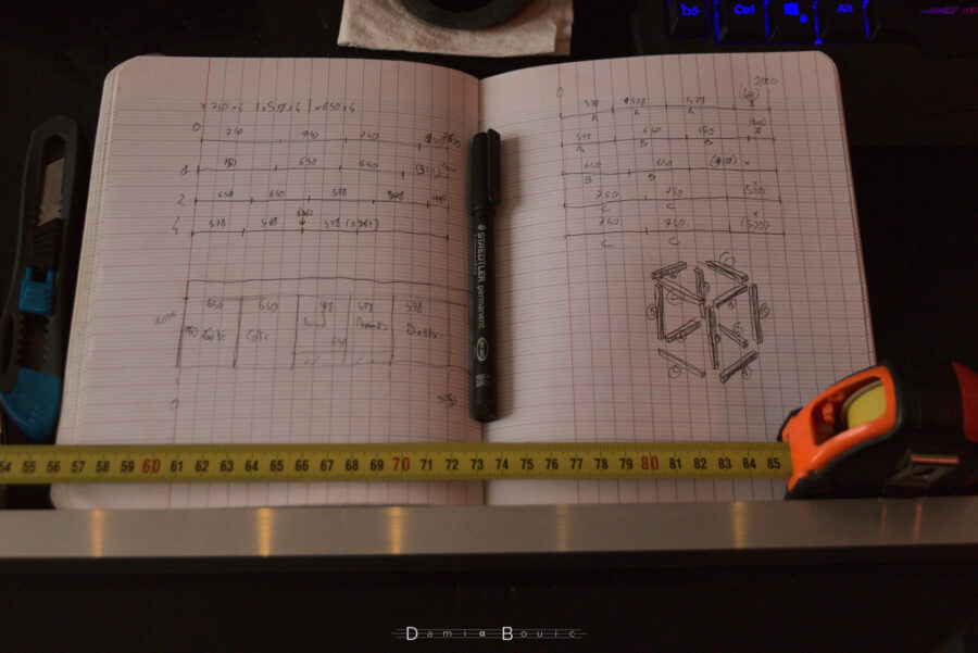 Deux pages intérieures de mon cahier de croquis détaillant le plan de coupe du multiglass et le plan de coupe des poutrelles en aluminium. Dessus sont posée règles en ruban et stylo feutre pour disposer les marquages sur l'une des poutrelles, posée juste en dessous, et dont on ne voit qu'une partie