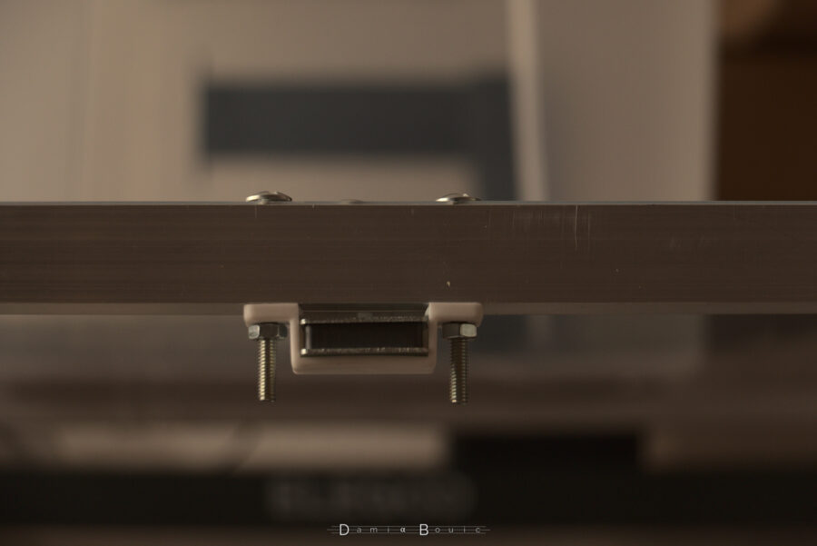 Détail sur le haut du caisson, où est disposé à l'aide de deux boulons un aimant qui tiendra la porte fermée.