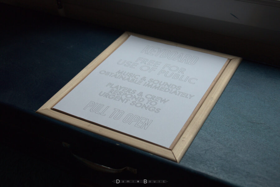 Sur le dessus de l'étui sont disposés des tasseaux fins qui forment un cadre autour d'une petite planche de bois, recouverte par un papier imprimé du texte TARDIS modifié