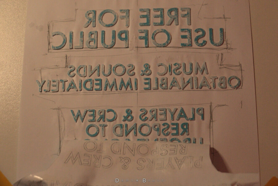 Je retire la feuille de papier, comme si c'était un sticker en fin de compte. On peut voir que de la peinture blanche a pu passer sous les lettres. Le texte se dévoile donc à l'envers, comme vu dans un miroir.