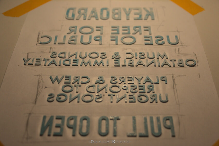 Vue globale en légère perspective sur ce même texte, après nettoyage de la base des lettres, pour les préparer à leur collage définitif.