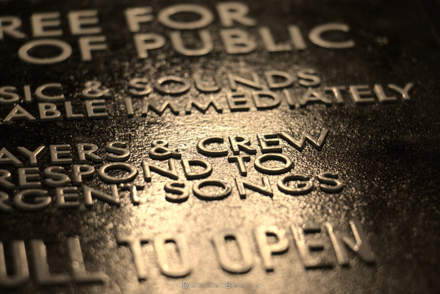 Zoom oblique sur le centre de la plaque montrant de belles lettres blanches bien lustrées sur une plaque noire brillante.