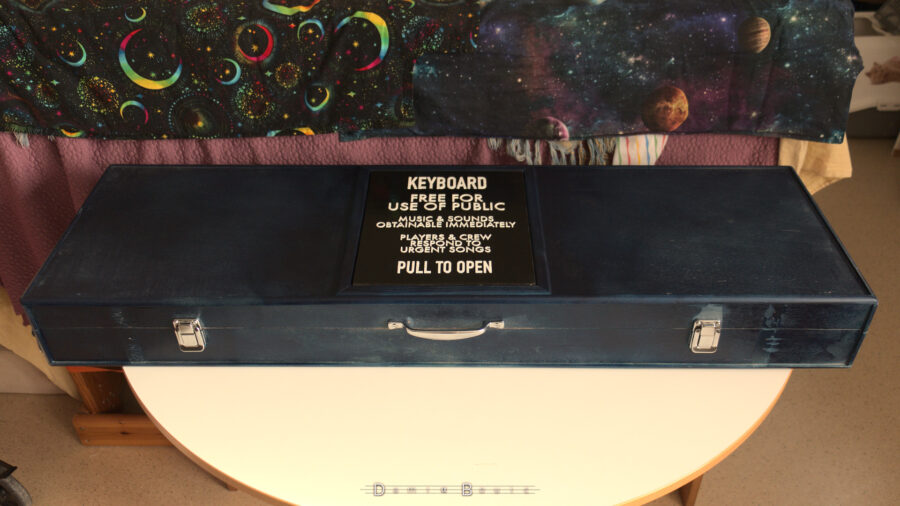 Vue globale de l'étui, la plaque TARDIS au centre, avec le texte PULL TO OPEN proche de la poignée qui incite à l'ouvrir.