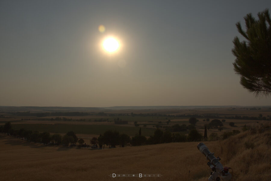 Le paysage qui va accueillir l'éclipse, avec la vue sur le plateau semi-aride. La vue est bordée à droite par un bout de pin, et une lunette astronomique verrouillée sur l'astre du jour
