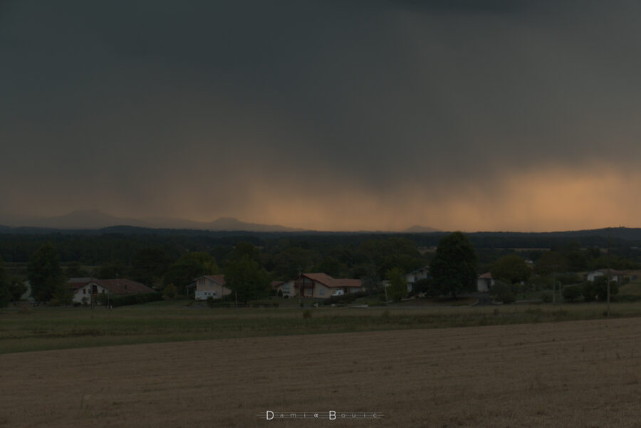 Zoom sur le rideau de pluie qui masque une partie des Pyrénées dans la lumière presque crépusculaire du soir.