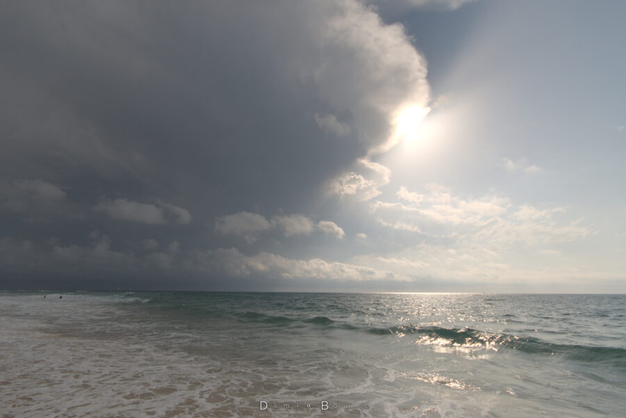 La même vue mais plus haute dans le ciel qui montre plus du nuage orageux qui recouvre de plus en plus le Soleil. Des rais de lumières bordent l'ombre du nuage qui se projette dans le ciel.
