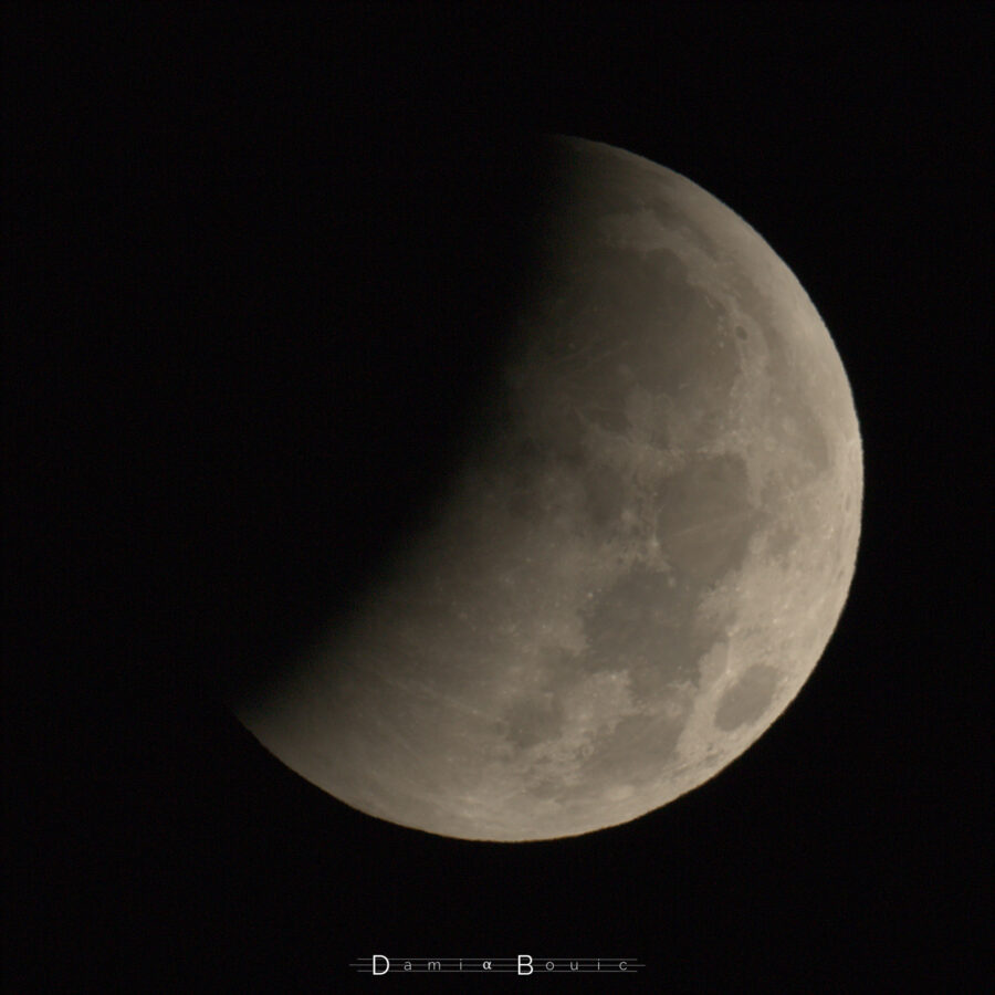 La Pleine Lune, dont toute une partie est plongée dans l'ombre de la Terre, qui forme une douce courbe arrondie sur le disque lunaire.