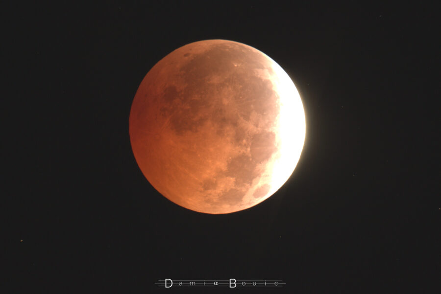 Une bonne partie de la Lune est dans l'ombre terrestre. La forte sensibilité de la prise de vue permet de bien mettre en évidence les teintes rouges des couleurs qui se posent sur l'astre, tandis que la portion hors ombre est surexposée. Des étoiles sont visibles sur un ciel qui n'est plus noir.